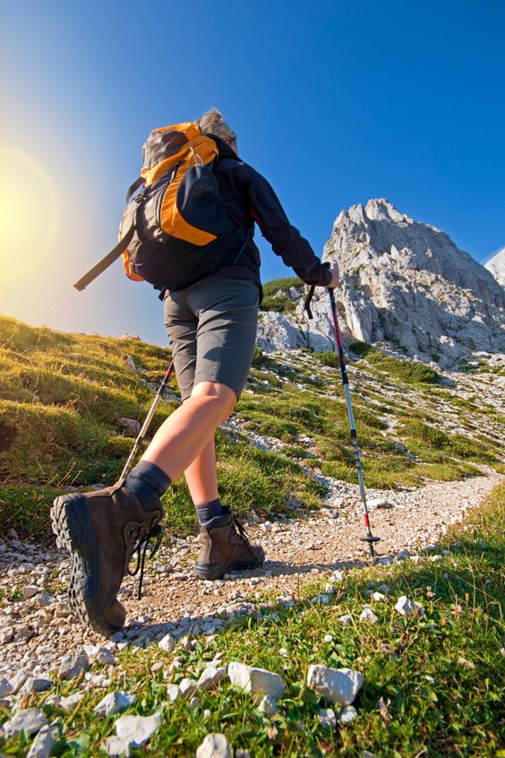 Backpacker organising clothing and travel gear beside an open backpack